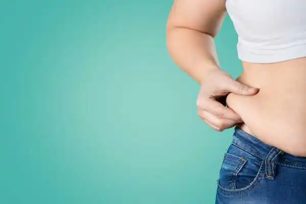 Image of woman pinching her love handles to show weight gain Scotland